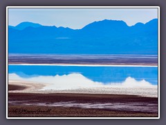 Wolkenspiegelungen an der Badwater Road im Salzwasser